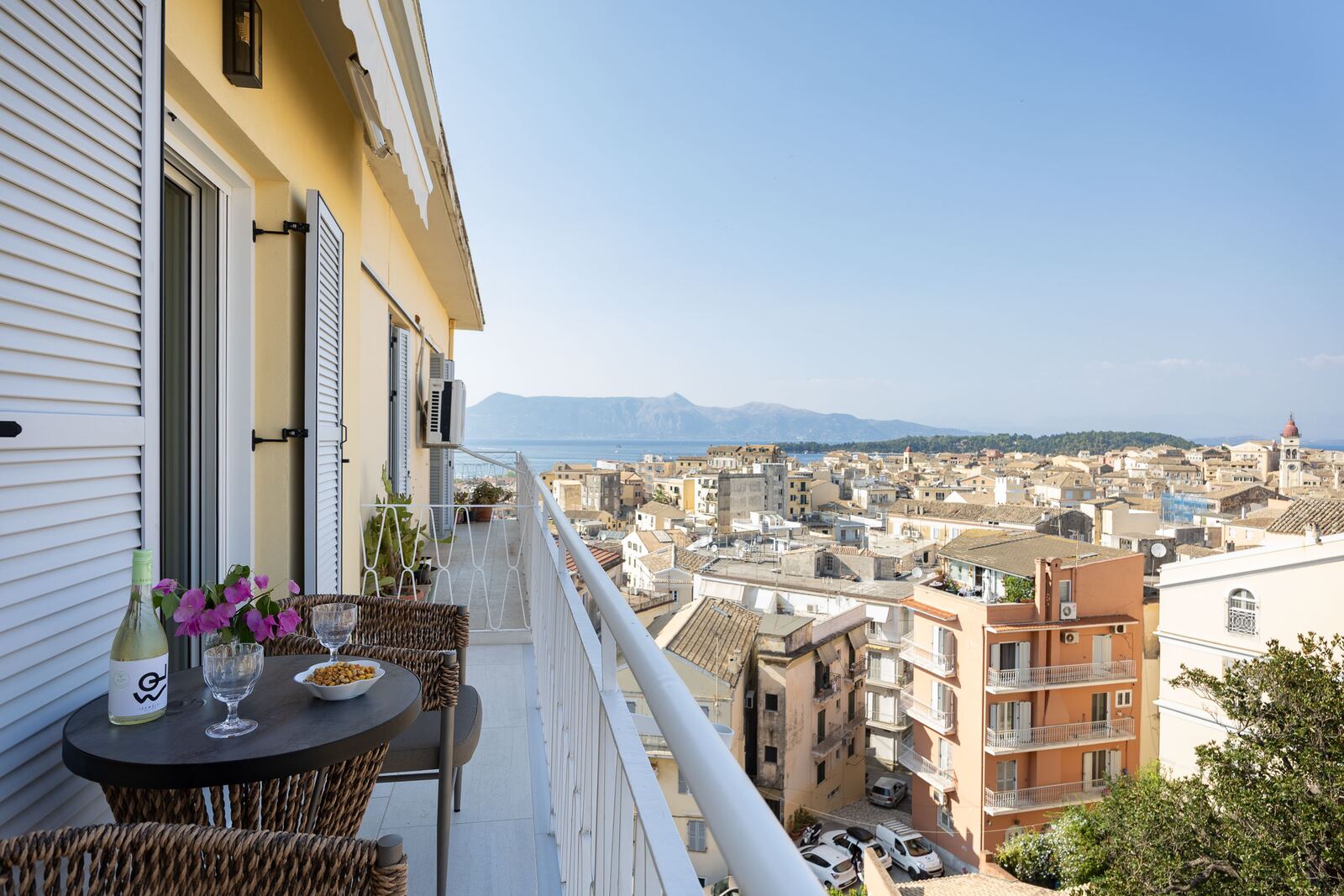 Balcony table set with wine and olives above the town