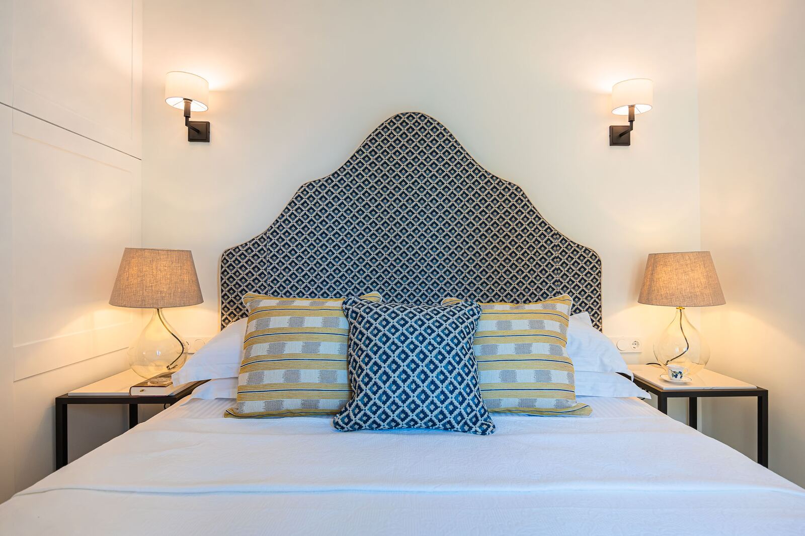 Bedroom three, double bed with a scalloped blue ikat headboard and bedside lamps