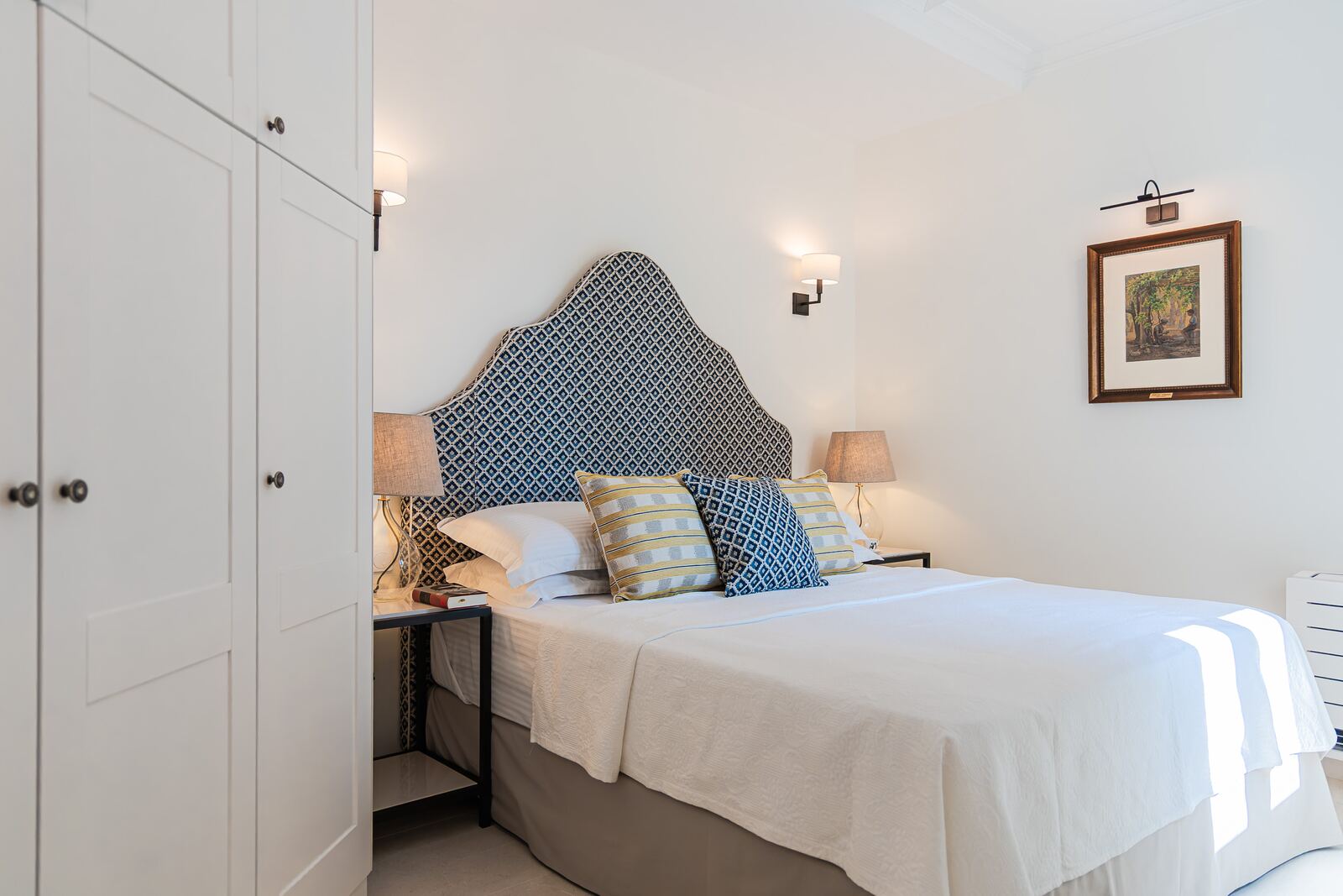 Bedroom one with fitted wardrobe and framed watercolour