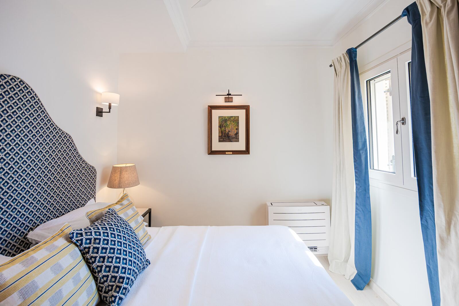 Bedroom one with shuttered window and blue curtains