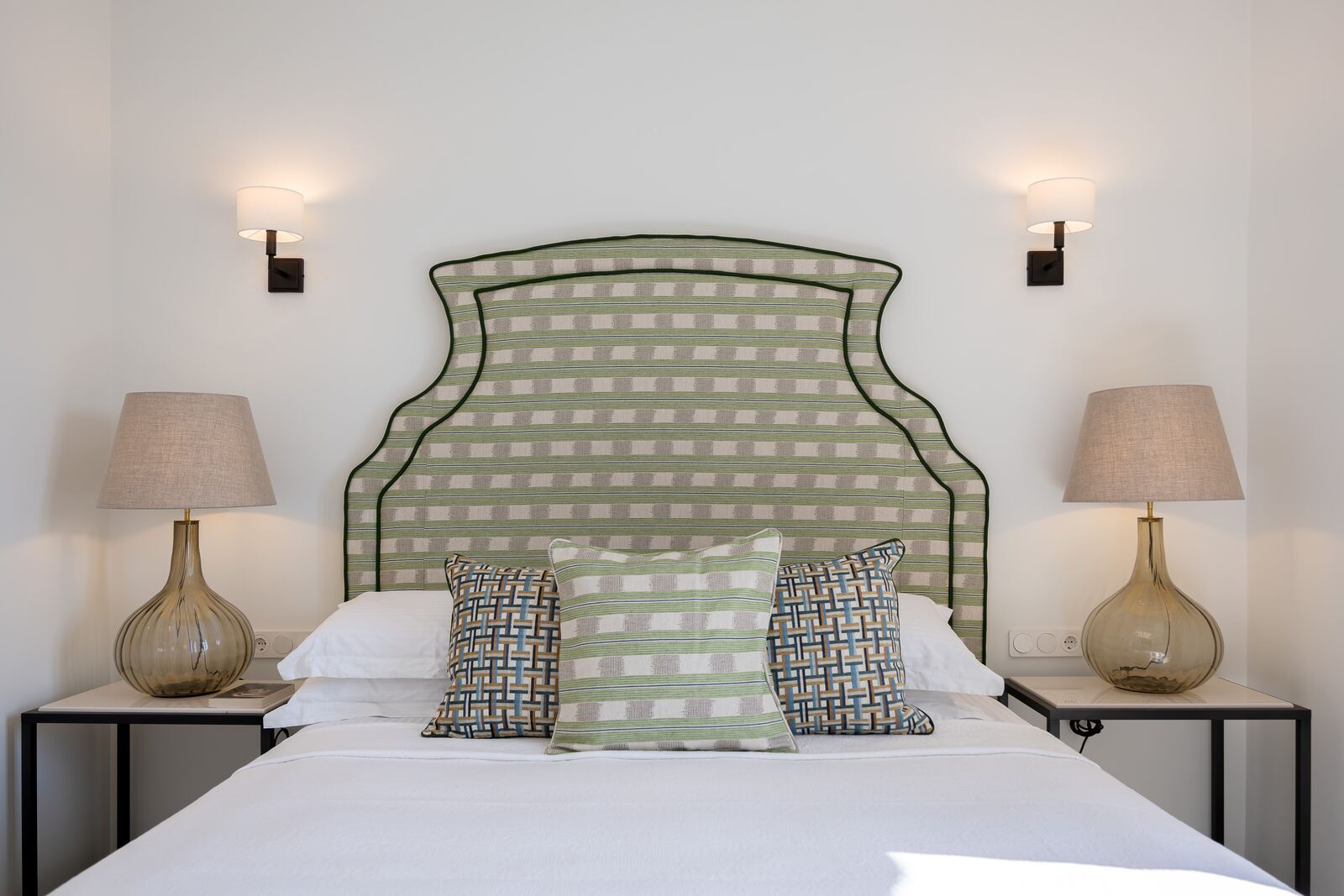 Bedroom one, double bed with an olive check headboard and bedside lamps