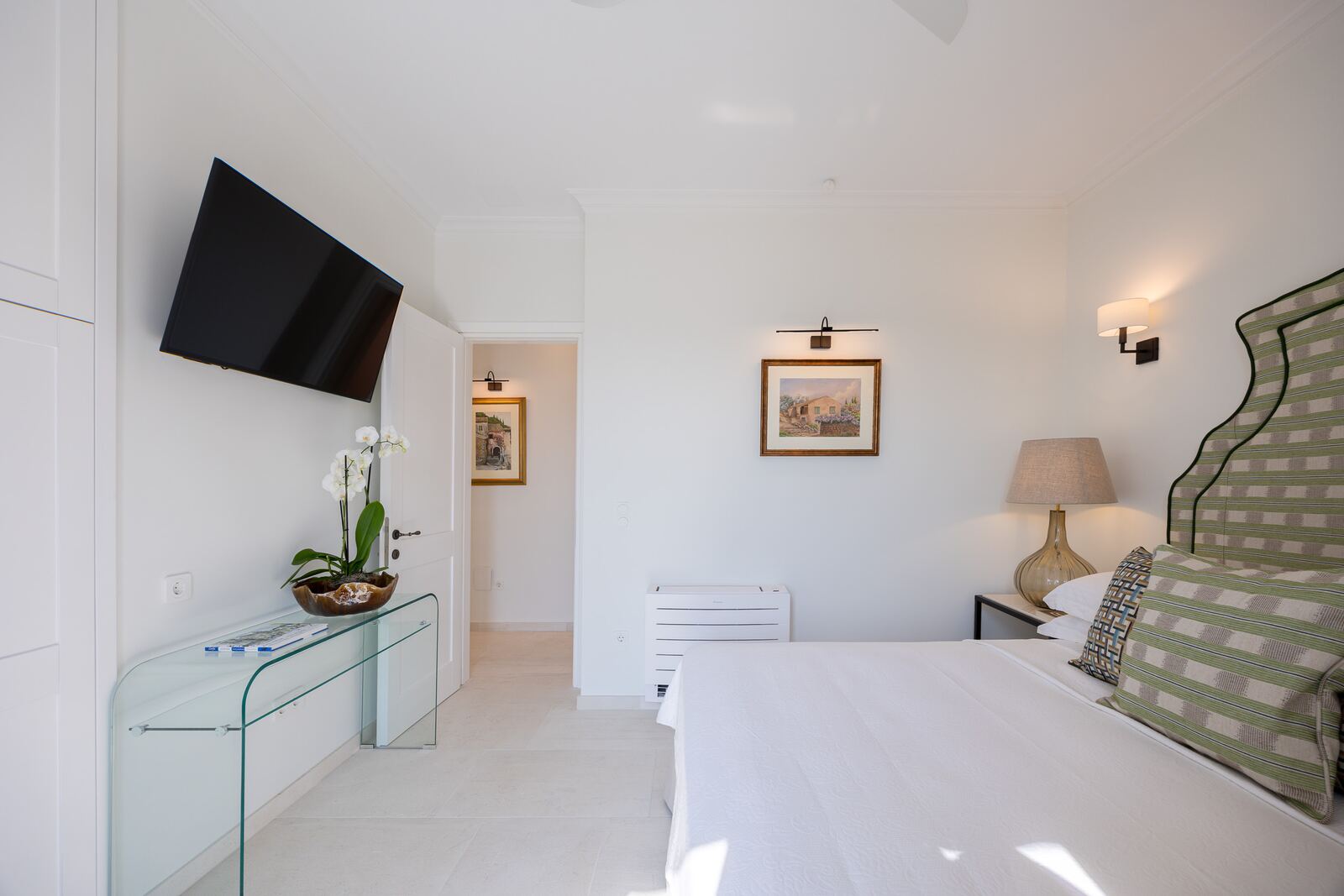 Bedroom three with smart television and glass console