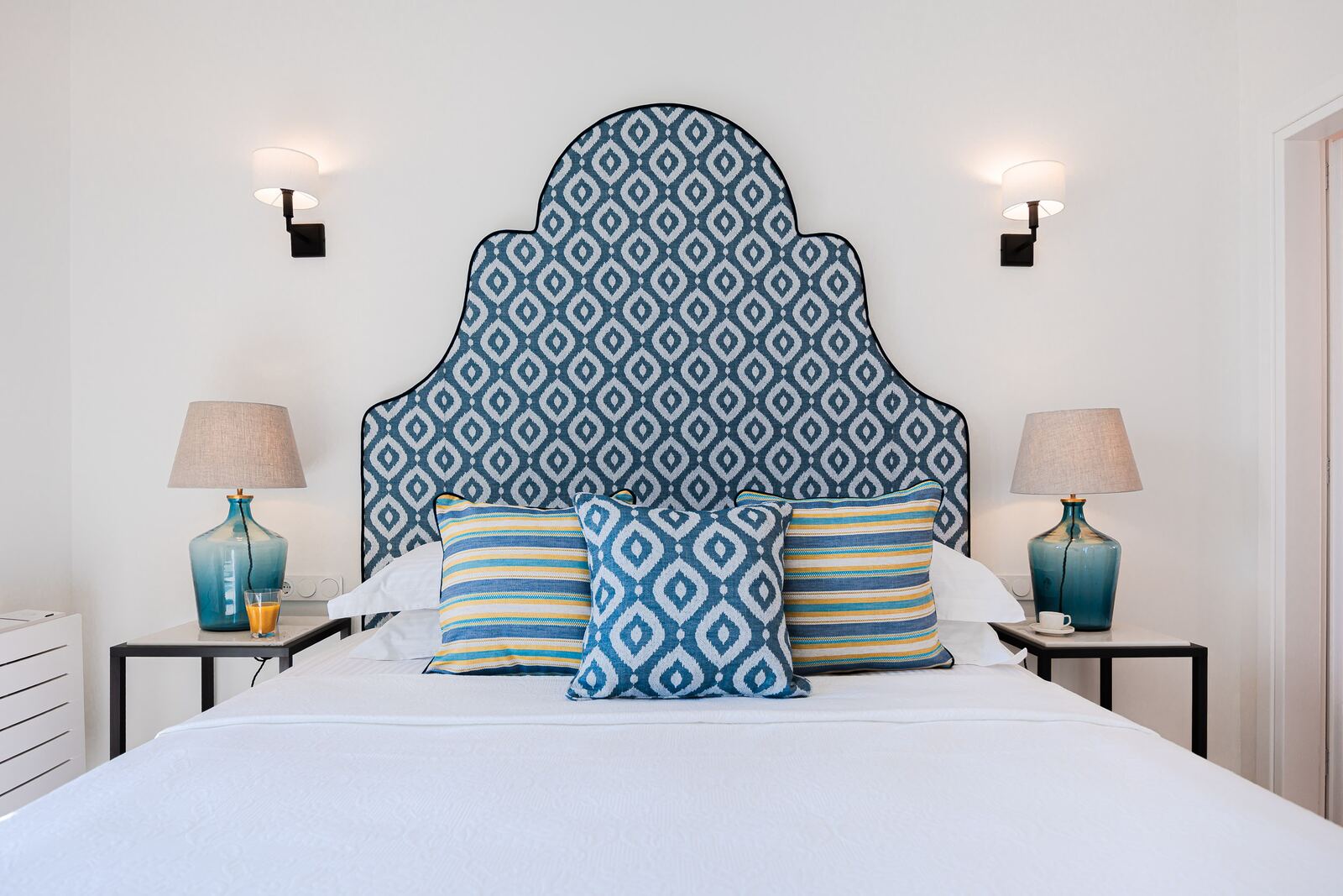 Bedroom two, double bed with a blue headboard and turquoise glass lamps