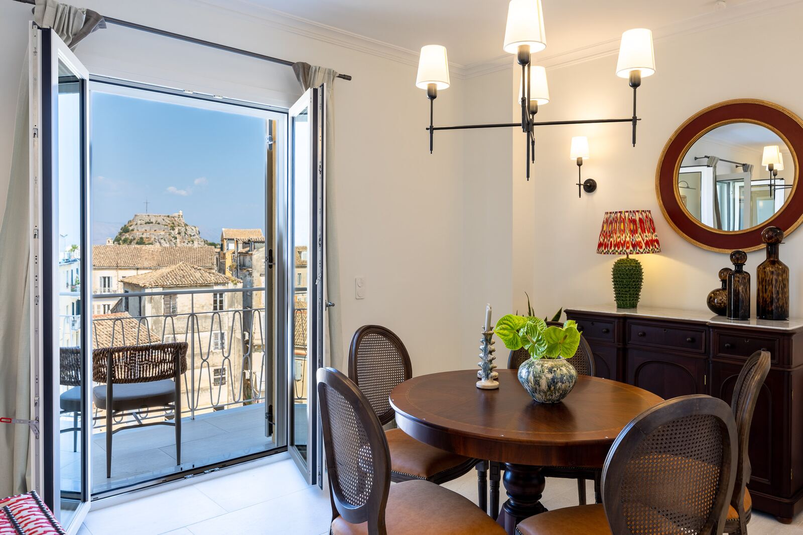 Dining table beside the open balcony doors with the Old Fortress beyond