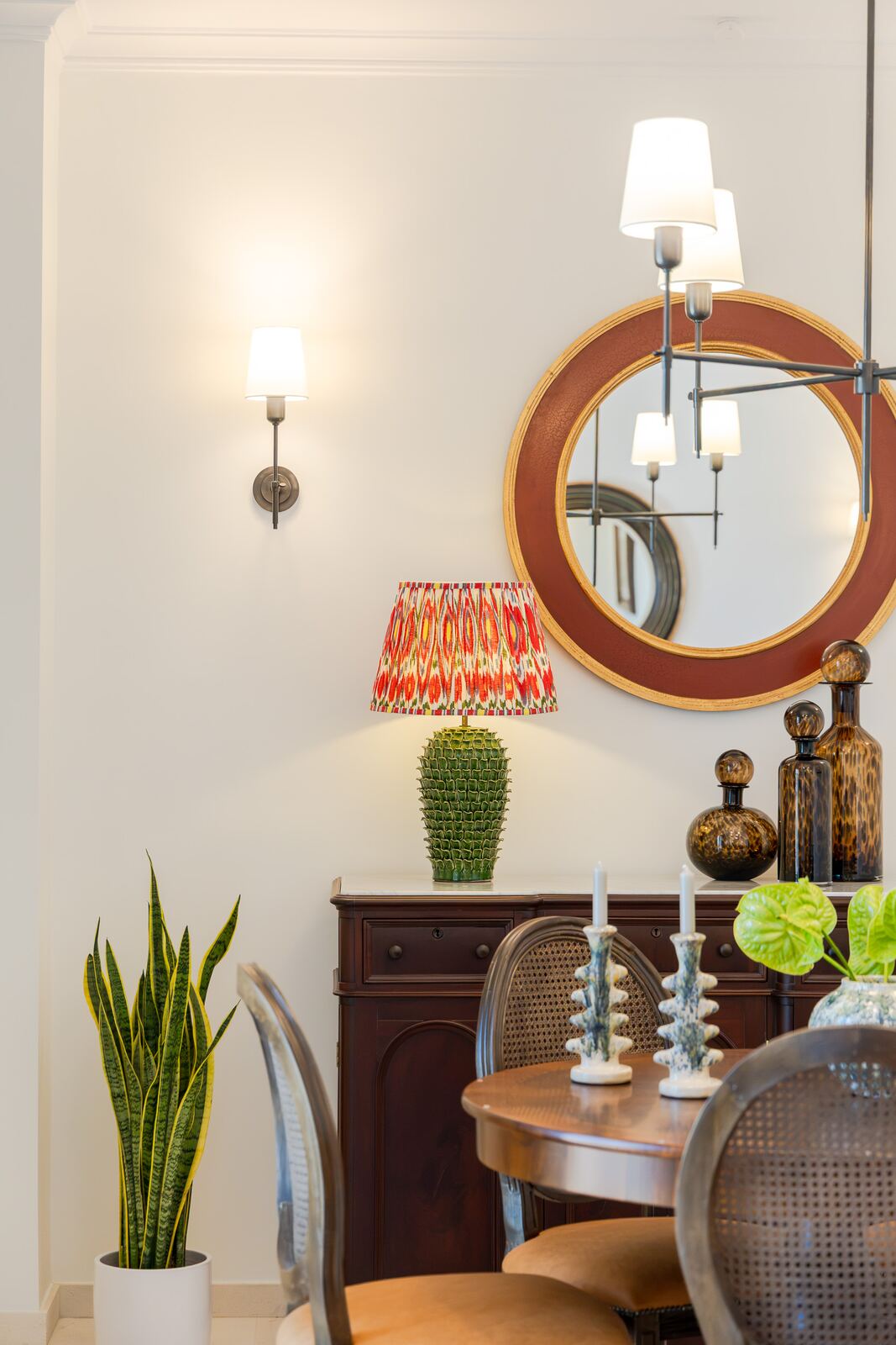 Dining room sideboard with round mirror and candlesticks