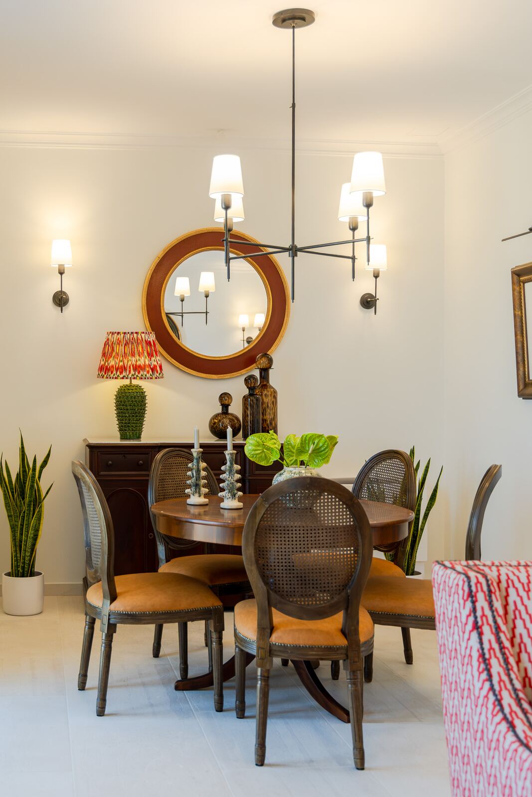 Round dining table for six under a wrought-iron chandelier