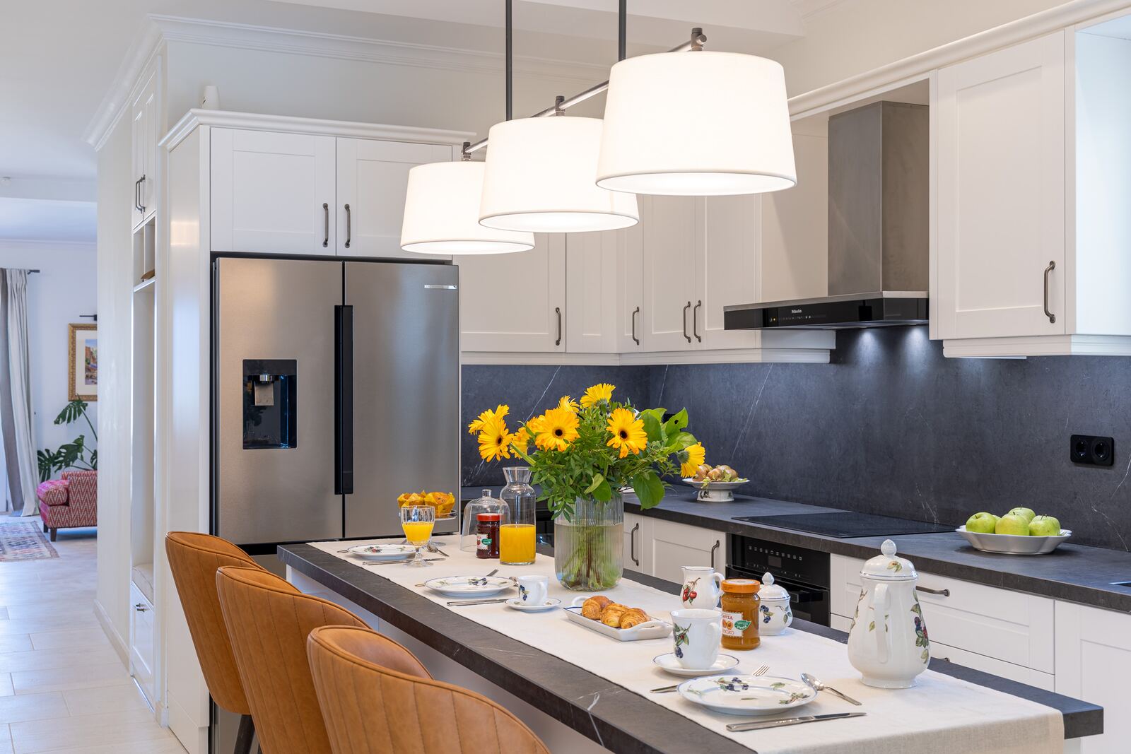 Kitchen island at Terra di Corfu laid for breakfast, with stone worktops and pendant lights