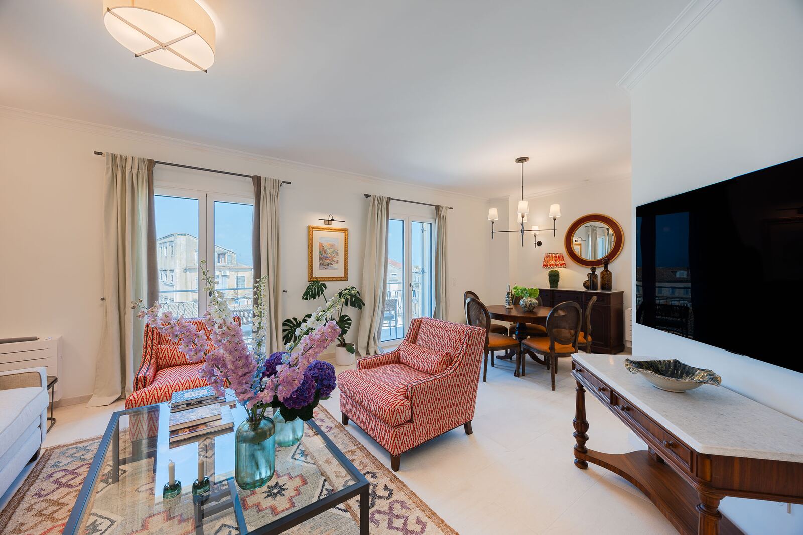 Living room and dining area with chandelier and smart television