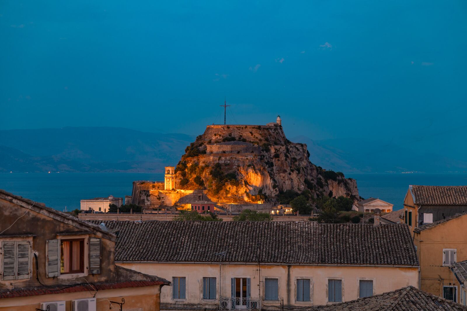 The Old Fortress floodlit at blue hour above the rooftops